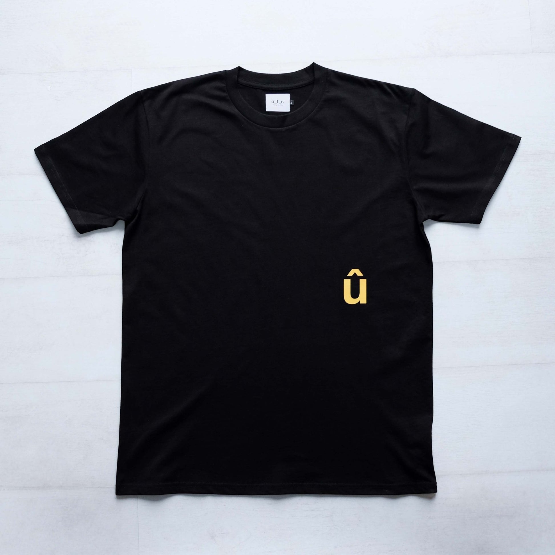 Front of black tshirt with a small yellow û print below pocket placment #bike #uptheroad