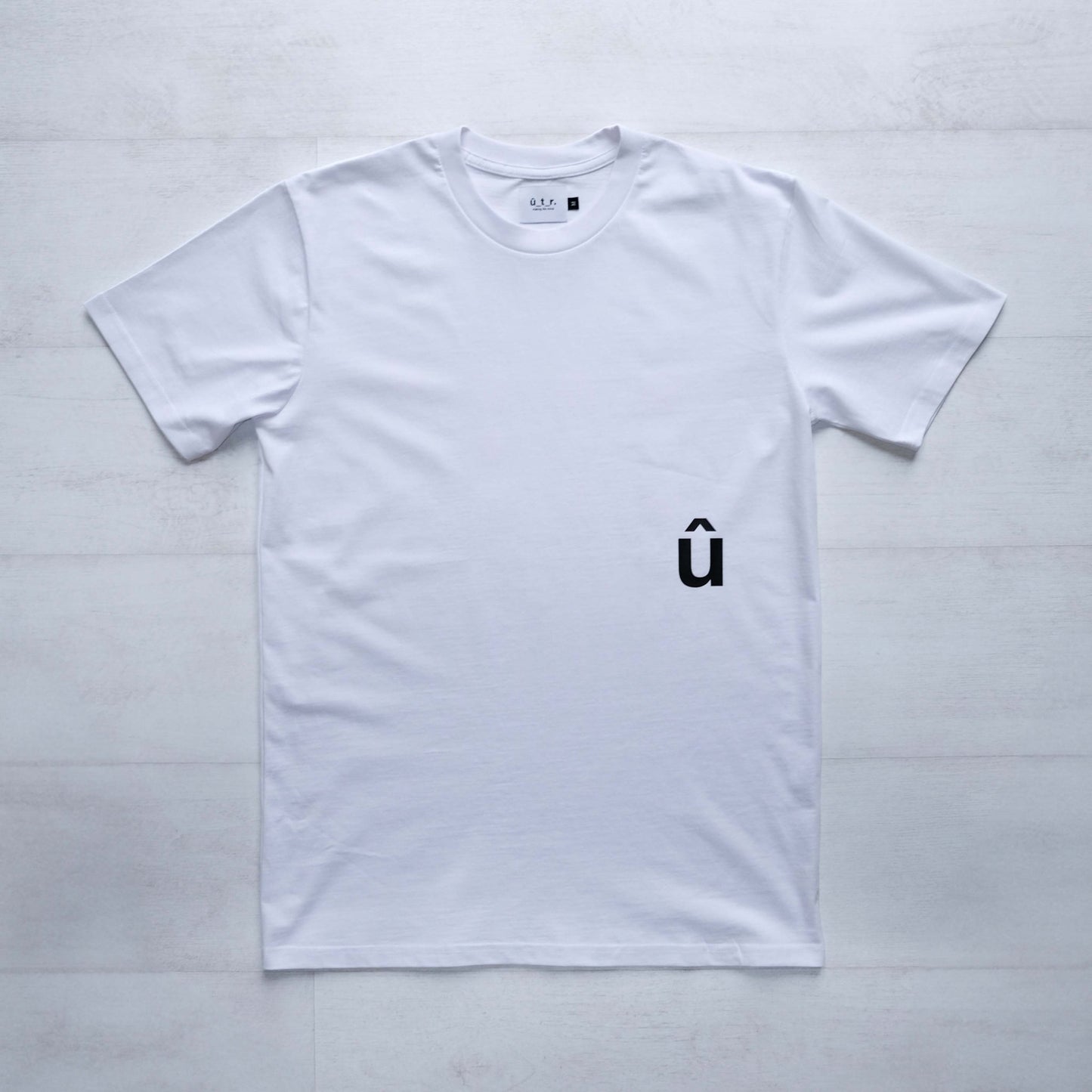 Front of white tshirt with a small black û print below pocket placment #bike #uptheroad